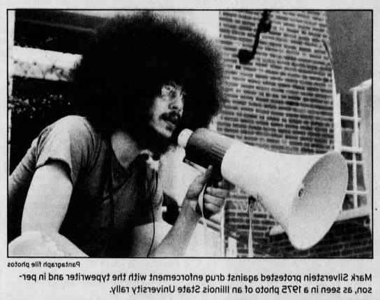 马克·西尔弗斯坦的照片及说明:马克·西尔弗斯坦亲自用打字机抗议毒品执法, 这是1975年伊利诺伊州立大学集会的照片